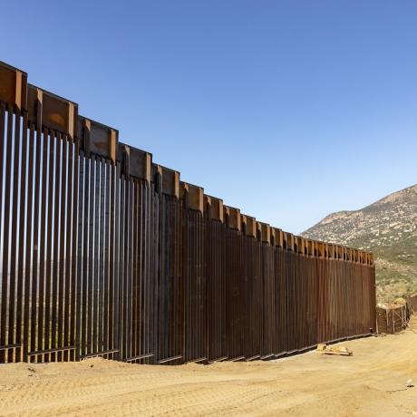High border wall separating the US and Mexico.